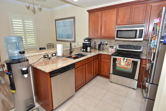 kitchen featuring light stone countertops, stainless steel appliances, crown molding, sink, and a chandelier