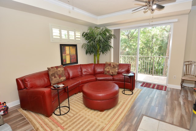 living room with a tray ceiling, ceiling fan, hardwood / wood-style floors, and ornamental molding