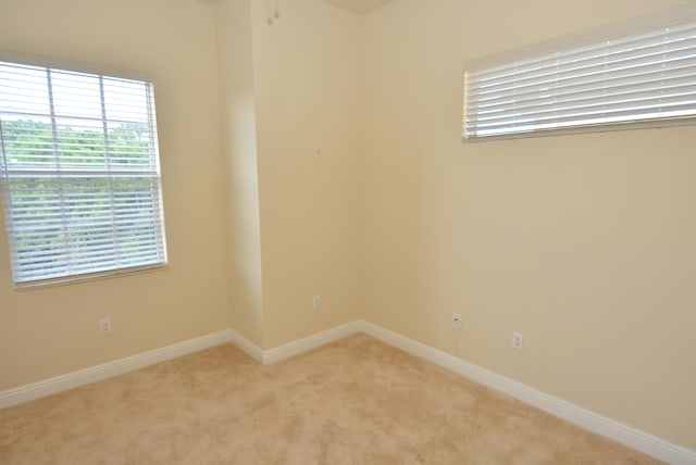 spare room featuring light carpet