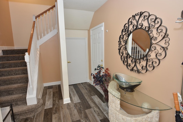 entrance foyer with dark hardwood / wood-style flooring and vaulted ceiling