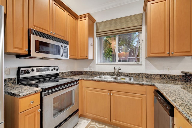 kitchen featuring light tile patterned floors, ornamental molding, dark stone countertops, sink, and stainless steel appliances