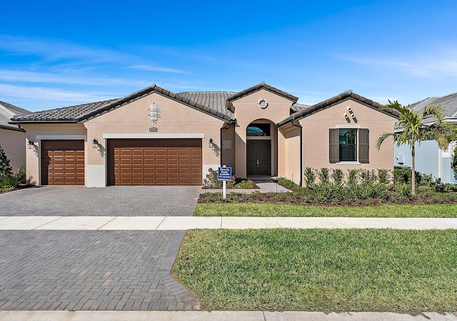 mediterranean / spanish-style house with a garage and a front yard