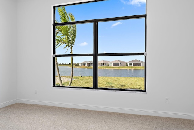 carpeted empty room with a water view