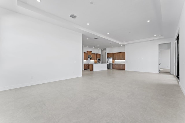 unfurnished living room featuring a raised ceiling