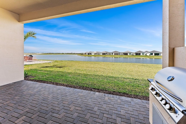 view of patio featuring area for grilling and a water view