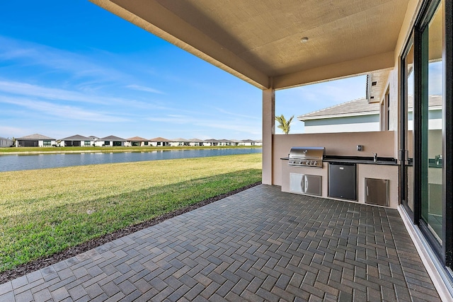 view of patio / terrace with a water view, area for grilling, sink, and grilling area