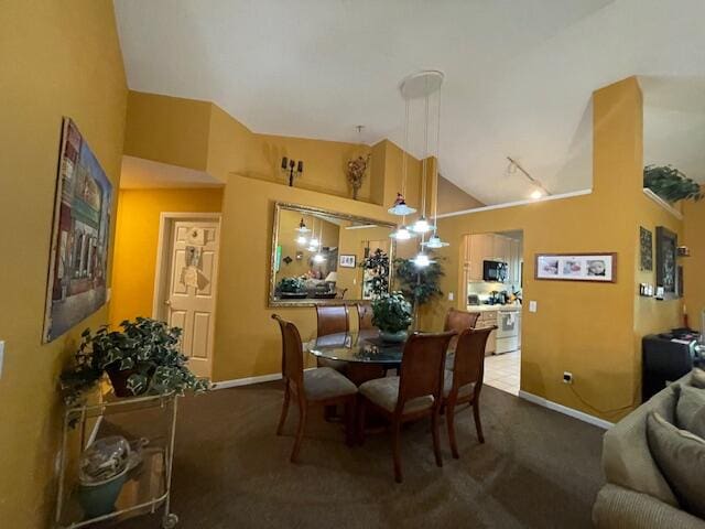 dining area featuring high vaulted ceiling and dark carpet