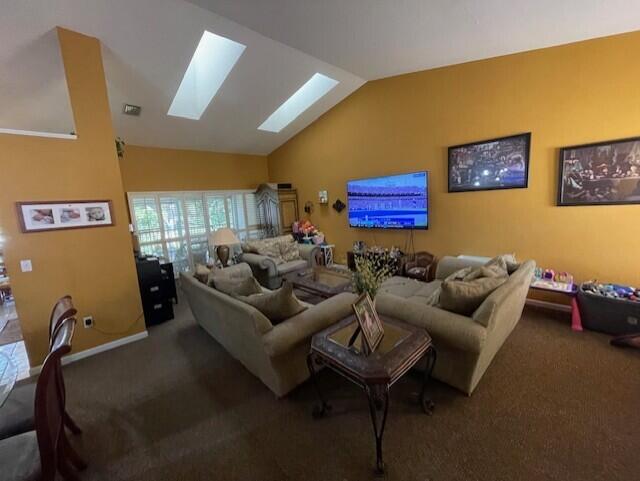 carpeted living room featuring lofted ceiling