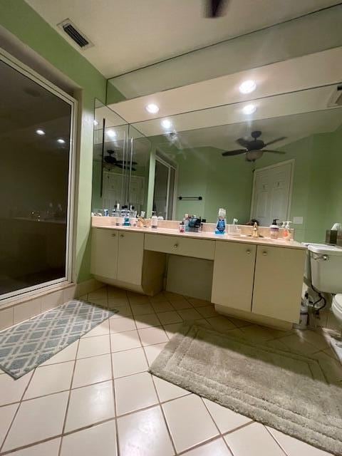 bathroom featuring tile patterned floors, vanity, ceiling fan, toilet, and a shower with shower door