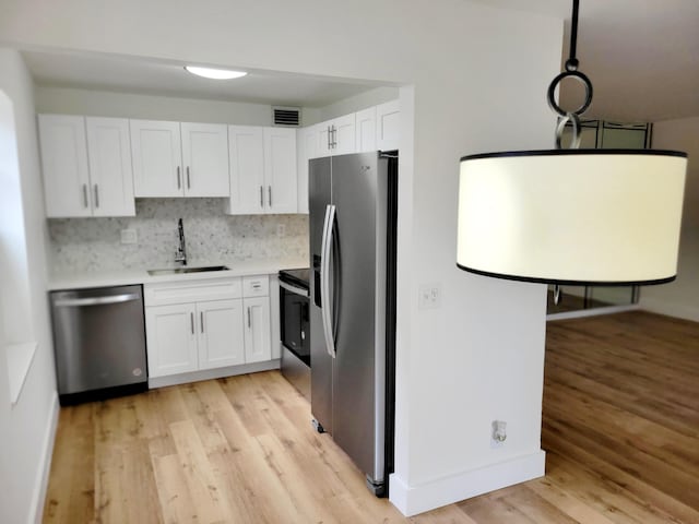 15 Burgundy Unit A, Delray Beach, FL 33484 - kitchen featuring a sink, visible vents, light wood-style flooring, white cabinetry, and appliances with stainless steel finishes