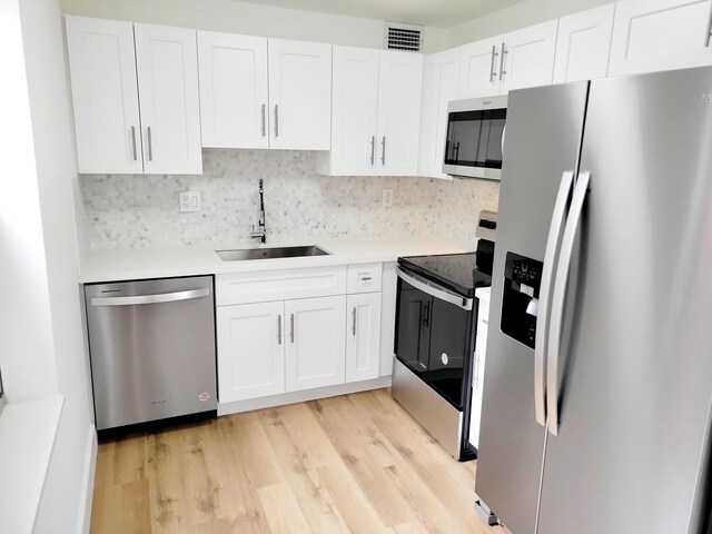 15 Burgundy Unit A, Delray Beach, FL 33484 - kitchen with a sink, appliances with stainless steel finishes, visible vents, white cabinetry, and light wood-style floors
