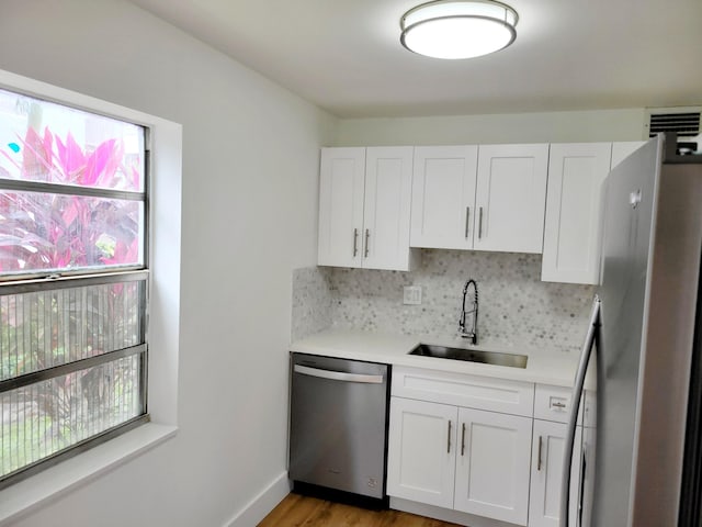 15 Burgundy Unit A, Delray Beach, FL 33484 - kitchen featuring a sink, white cabinetry, decorative backsplash, light countertops, and appliances with stainless steel finishes