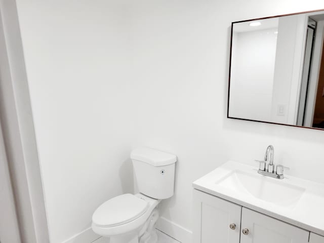 15 Burgundy Unit A, Delray Beach, FL 33484 - bathroom featuring vanity, toilet, and baseboards