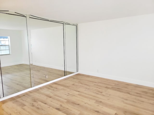 15 Burgundy Unit A, Delray Beach, FL 33484 - unfurnished bedroom featuring a closet, wood finished floors, and baseboards