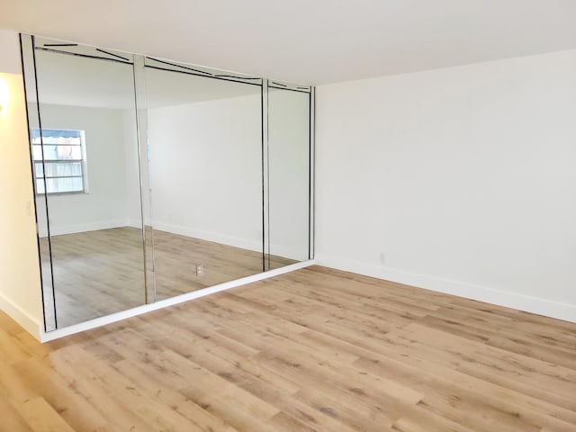 15 Burgundy Unit A, Delray Beach, FL 33484 - unfurnished bedroom featuring a closet, wood finished floors, and baseboards