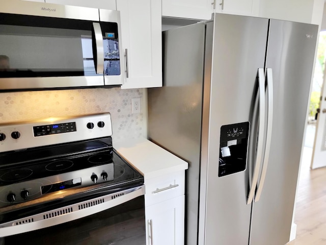 15 Burgundy Unit A, Delray Beach, FL 33484 - kitchen featuring wood finished floors, stainless steel appliances, white cabinets, light countertops, and tasteful backsplash