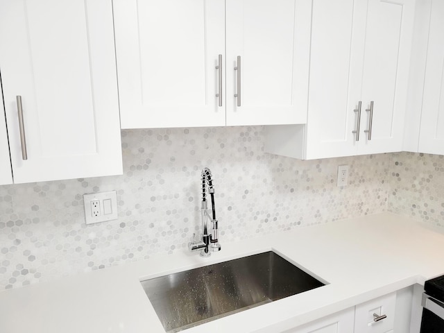 15 Burgundy Unit A, Delray Beach, FL 33484 - interior details featuring a sink, white cabinetry, light countertops, and tasteful backsplash