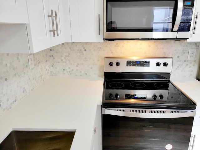 kitchen with appliances with stainless steel finishes and white cabinetry