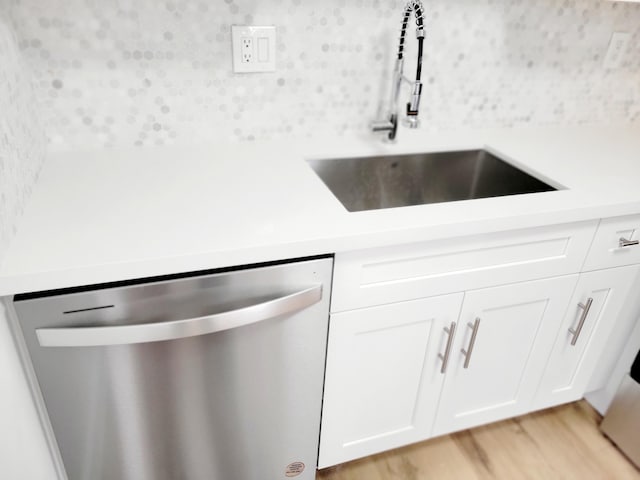 15 Burgundy Unit A, Delray Beach, FL 33484 - room details with a sink, tasteful backsplash, light wood finished floors, white cabinets, and stainless steel dishwasher