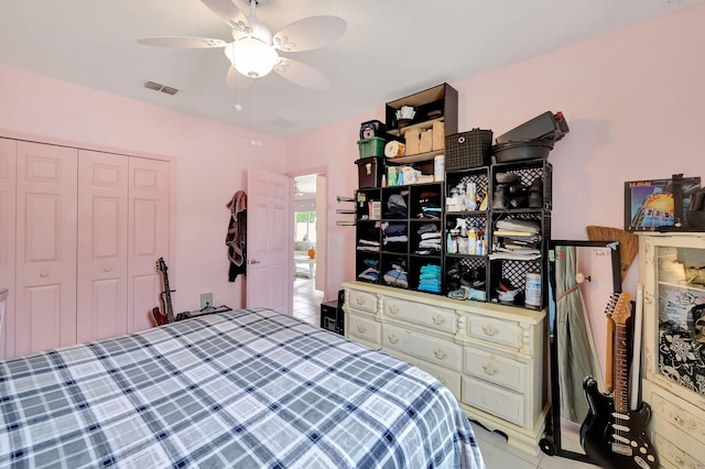 tiled bedroom featuring ceiling fan and a closet