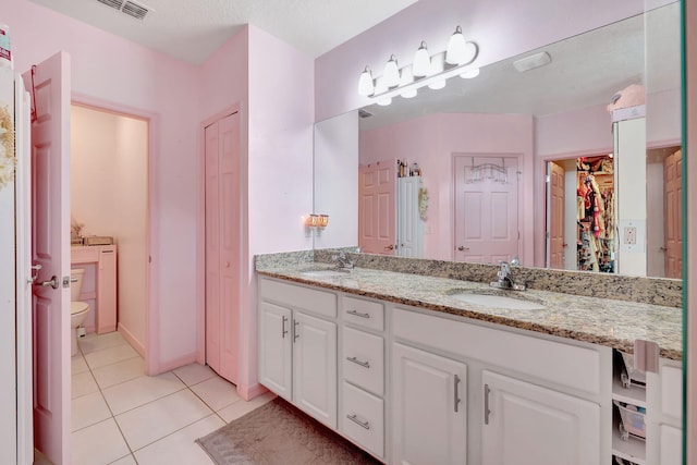 bathroom with vanity, tile patterned flooring, toilet, and a textured ceiling