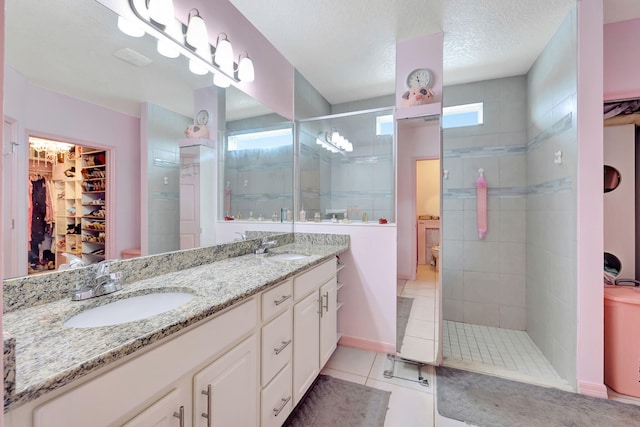 bathroom featuring tile patterned flooring, a shower with door, vanity, and a wealth of natural light