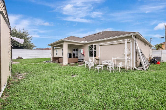 rear view of property with a lawn