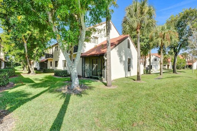 back of property with a sunroom and a yard