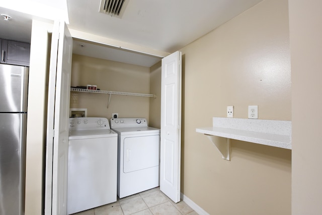 washroom featuring separate washer and dryer and light tile patterned floors