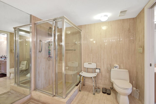 bathroom featuring a shower with door, wooden walls, and toilet