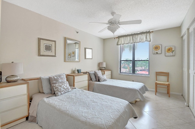 tiled bedroom featuring a closet, a textured ceiling, and ceiling fan