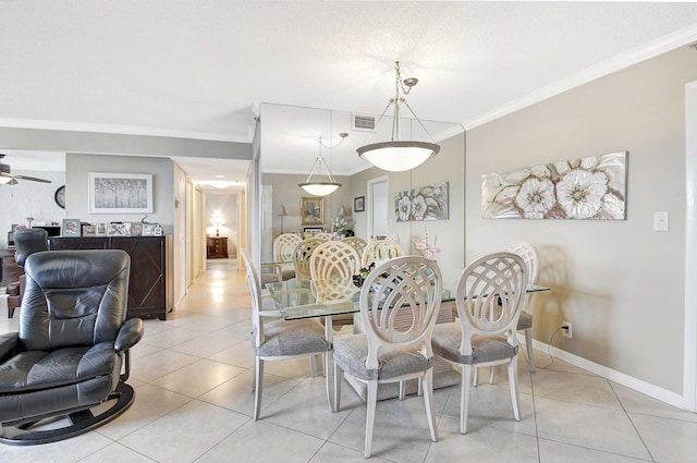 tiled dining room with ceiling fan, a textured ceiling, and ornamental molding