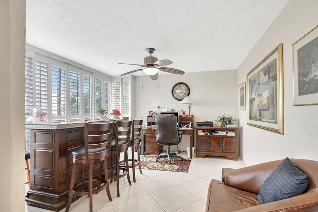 tiled office with ceiling fan, bar, and a textured ceiling