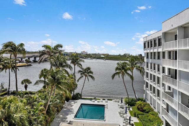 view of swimming pool featuring a water view and a patio