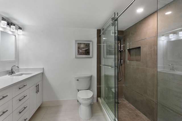 bathroom with tile patterned floors, vanity, a shower with shower door, and toilet