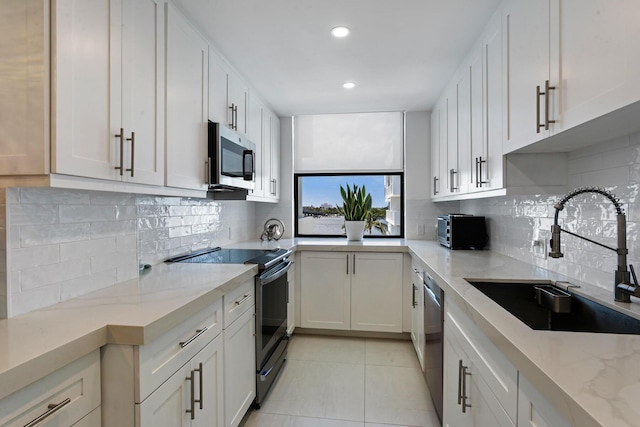 kitchen with sink, white cabinets, and stainless steel appliances