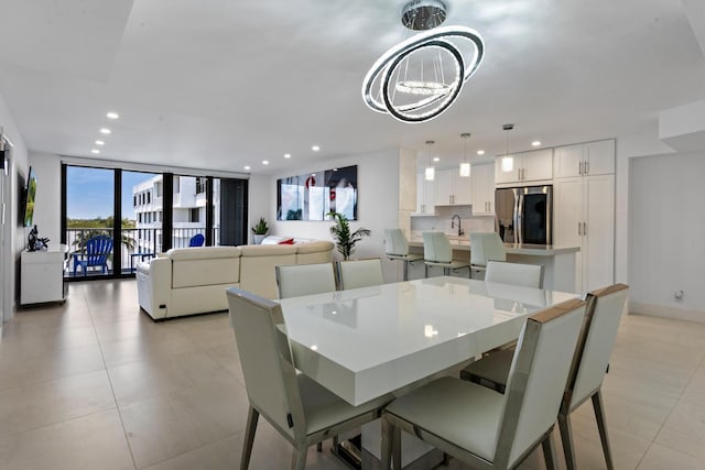 dining space featuring a wall of windows, sink, and an inviting chandelier