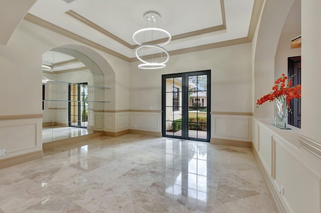 unfurnished room featuring ornamental molding, french doors, and a tray ceiling