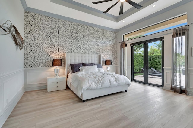 bedroom with a raised ceiling, ceiling fan, french doors, access to exterior, and light hardwood / wood-style flooring