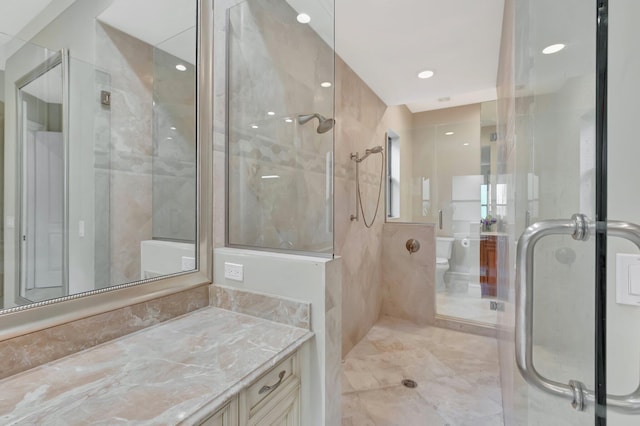 bathroom featuring toilet, a shower with shower door, and vanity