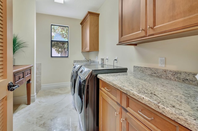 washroom with washing machine and clothes dryer and cabinets