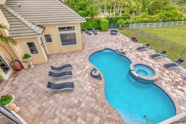 view of pool featuring a patio, a lawn, and an in ground hot tub