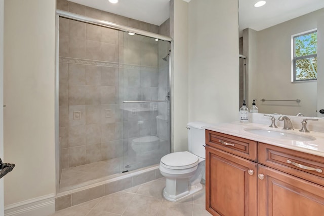 bathroom with tile patterned flooring, a shower with shower door, vanity, and toilet