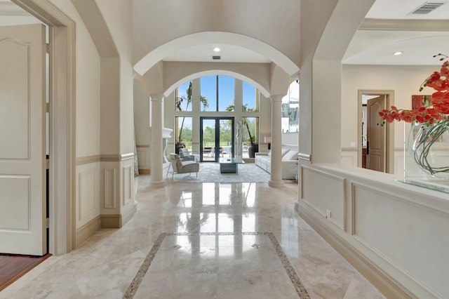 hall with decorative columns and french doors