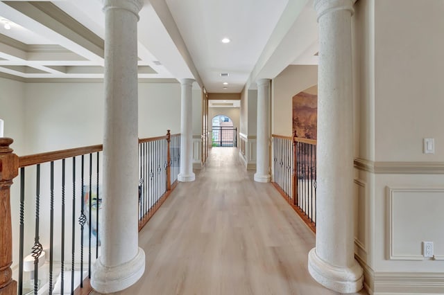 corridor featuring coffered ceiling, light wood-type flooring, crown molding, and beamed ceiling