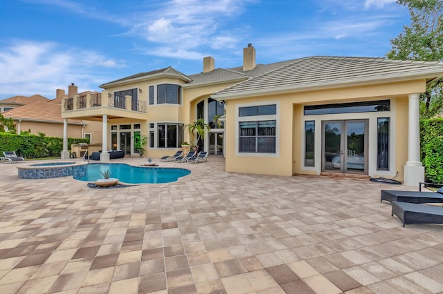 view of swimming pool with french doors, an in ground hot tub, and a patio