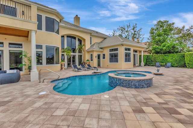 view of swimming pool featuring a patio and an in ground hot tub