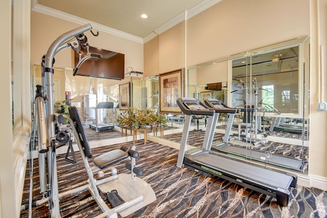 exercise room with ornamental molding and carpet flooring