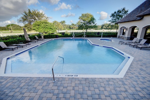 view of swimming pool with a community hot tub and a patio area