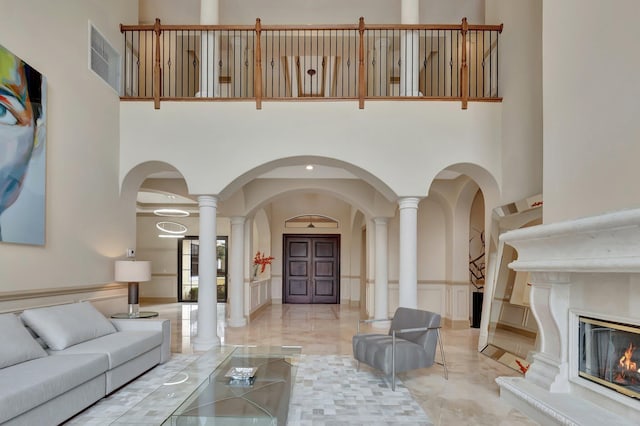 living room with a towering ceiling and ornate columns